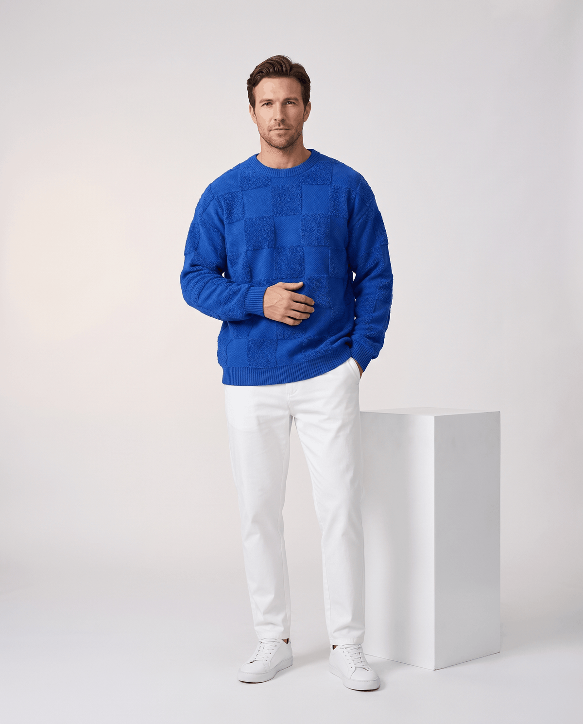 Full-length blue checkerboard sweater outfit with white trousers and sneakers