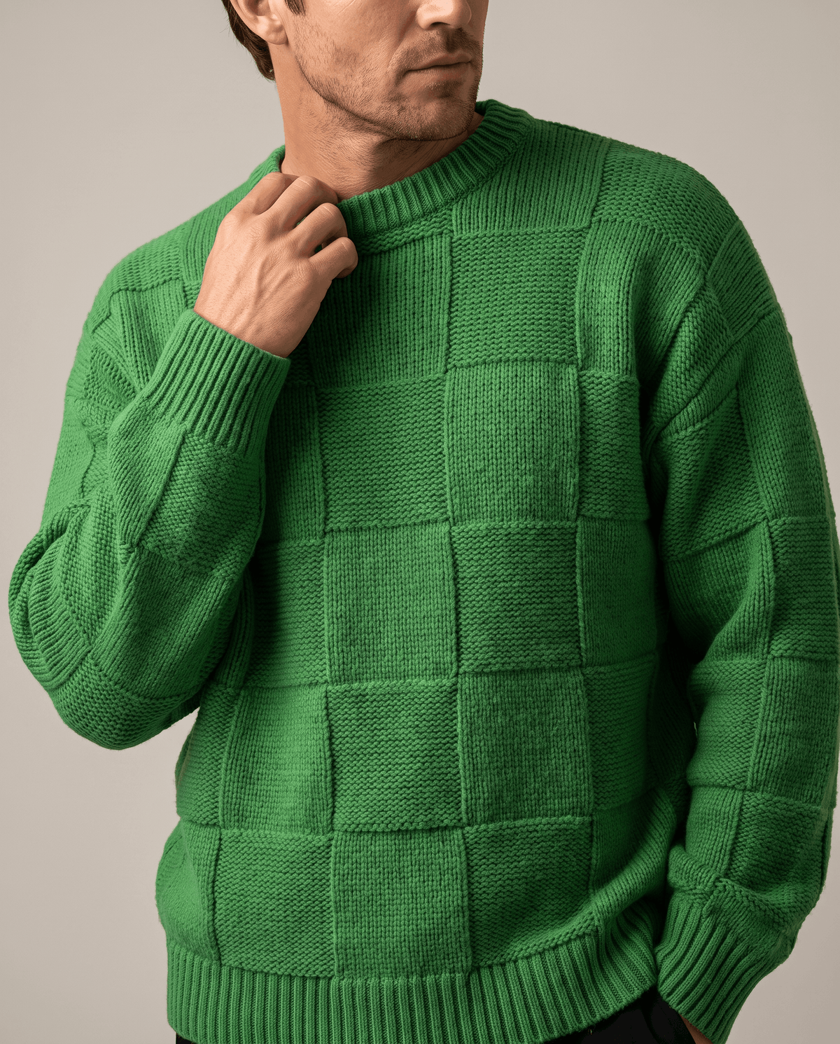 Close-up of hand at the ribbed collar of a green textured knit