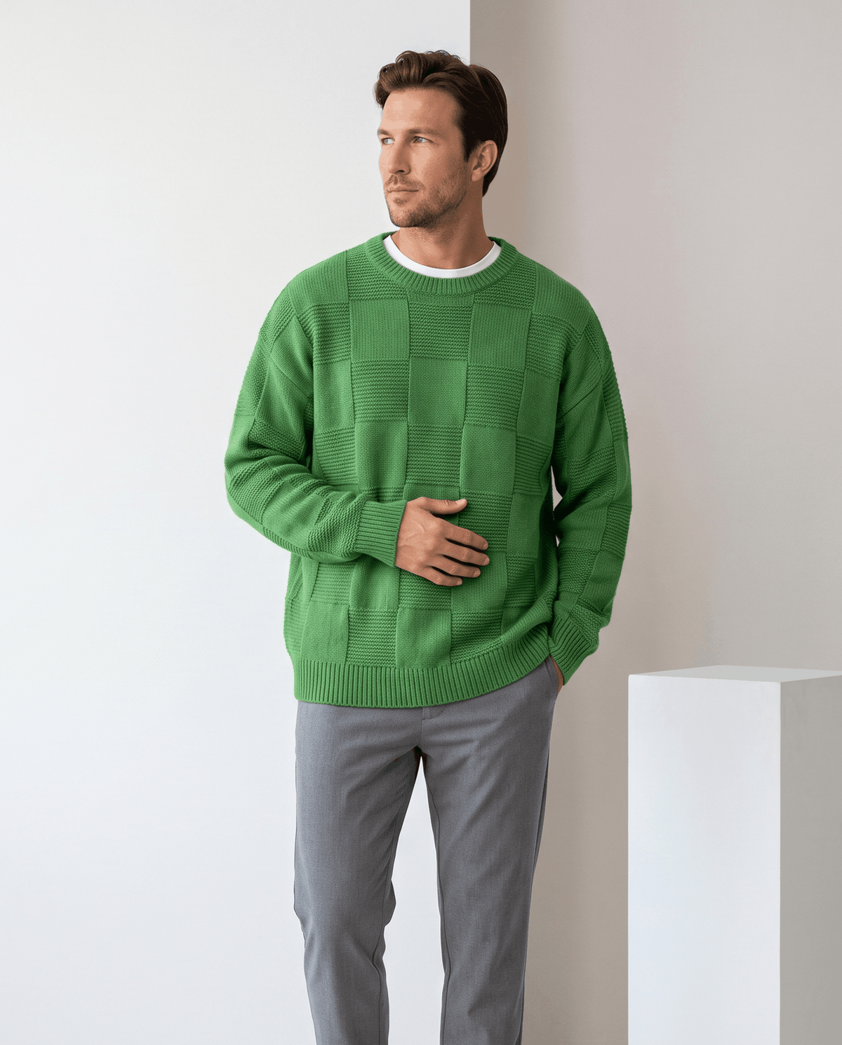 Model in green oversized checkerboard knit sweater with gray trousers