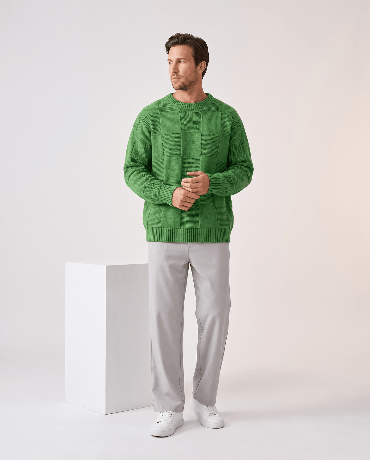 Full-length green checkerboard sweater look with gray trousers and sneakers