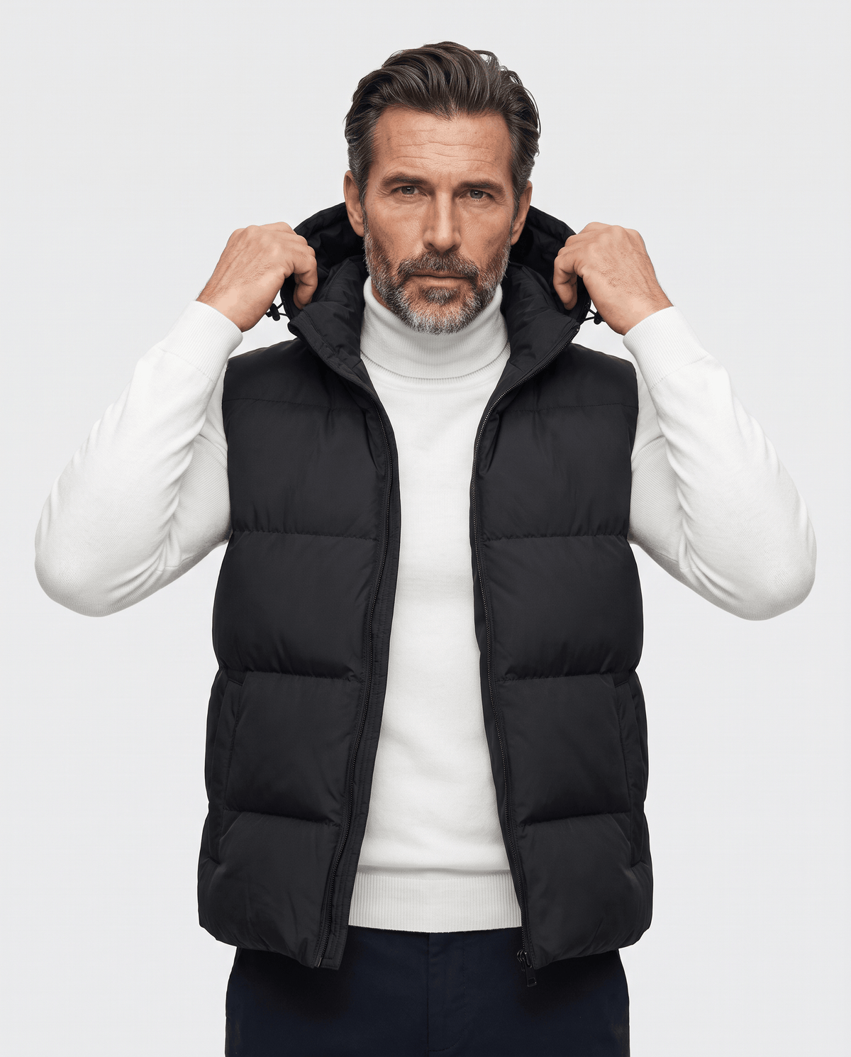 Black padded hooded vest worn over a white sweater, front view