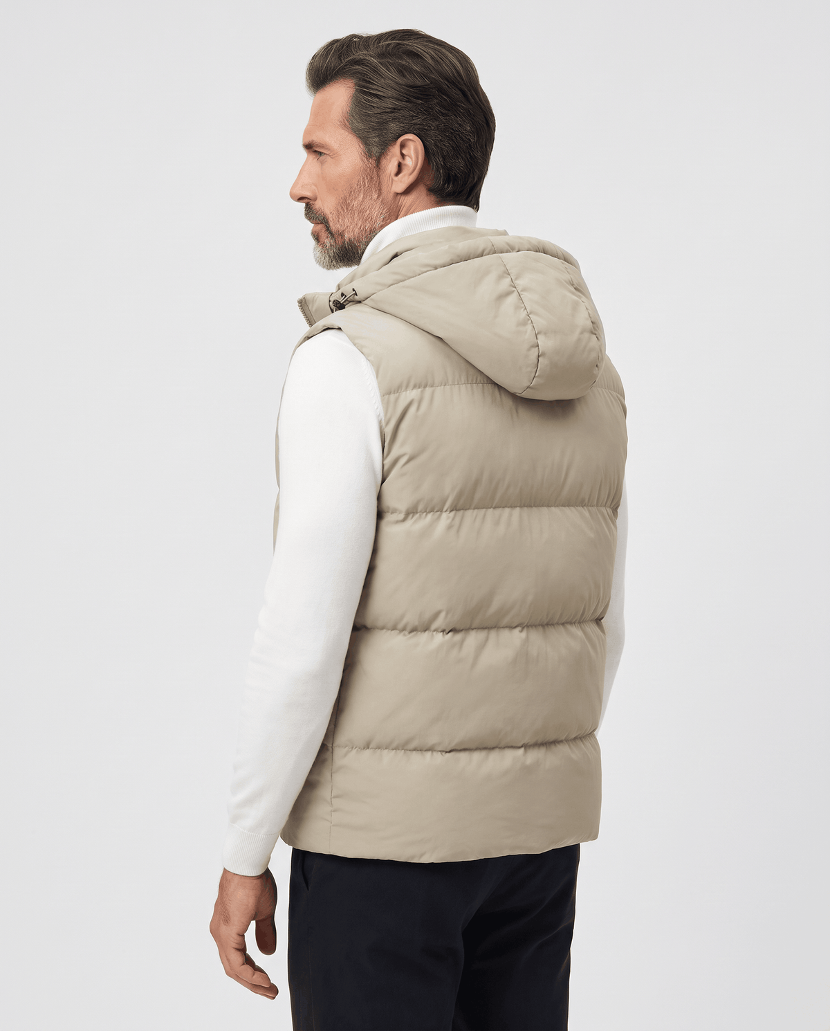 Side-back view of khaki padded hooded vest on a model