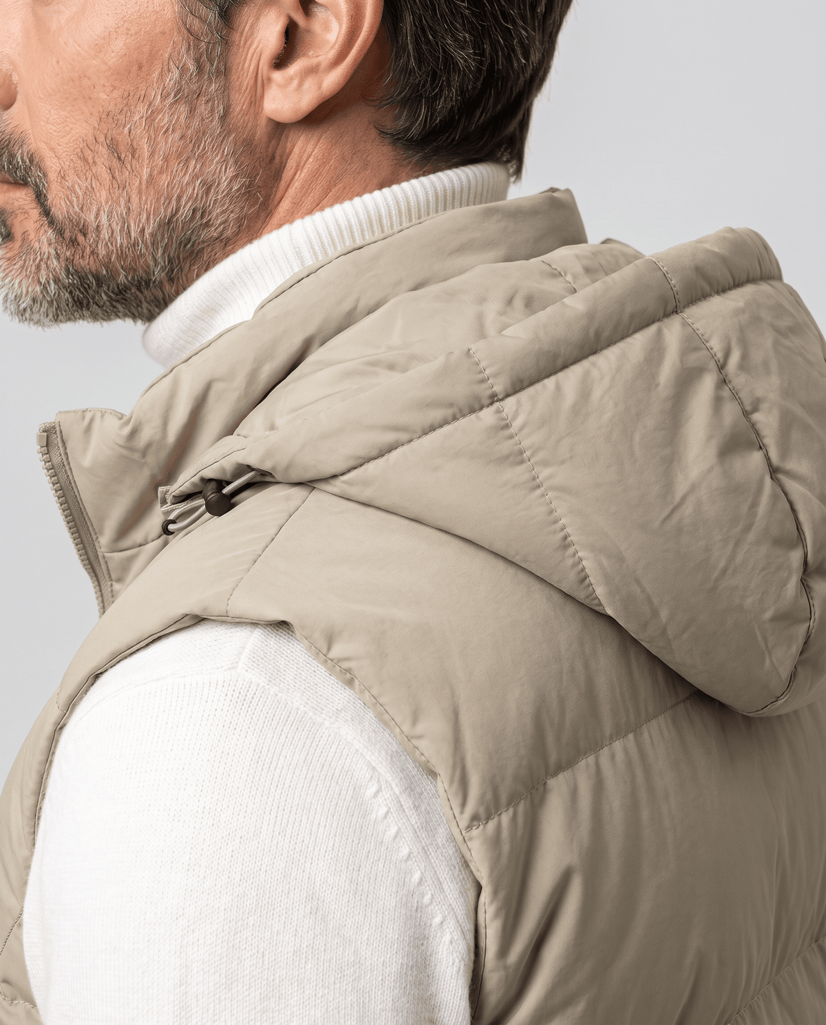 Khaki padded vest hood and shoulder shown in close view