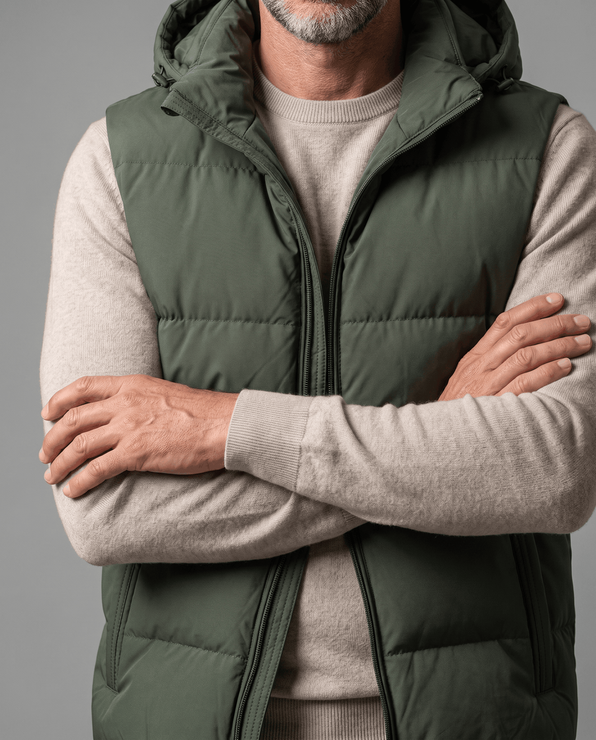 Military green padded vest front zip and horizontal panels with arms crossed