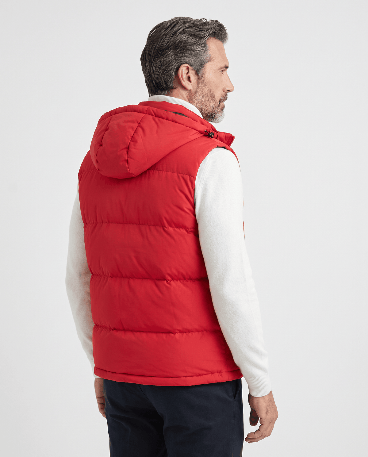 Side-back view of red padded hooded vest on a model