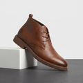 Brown leather lace-up ankle boot displayed on a white pedestal.