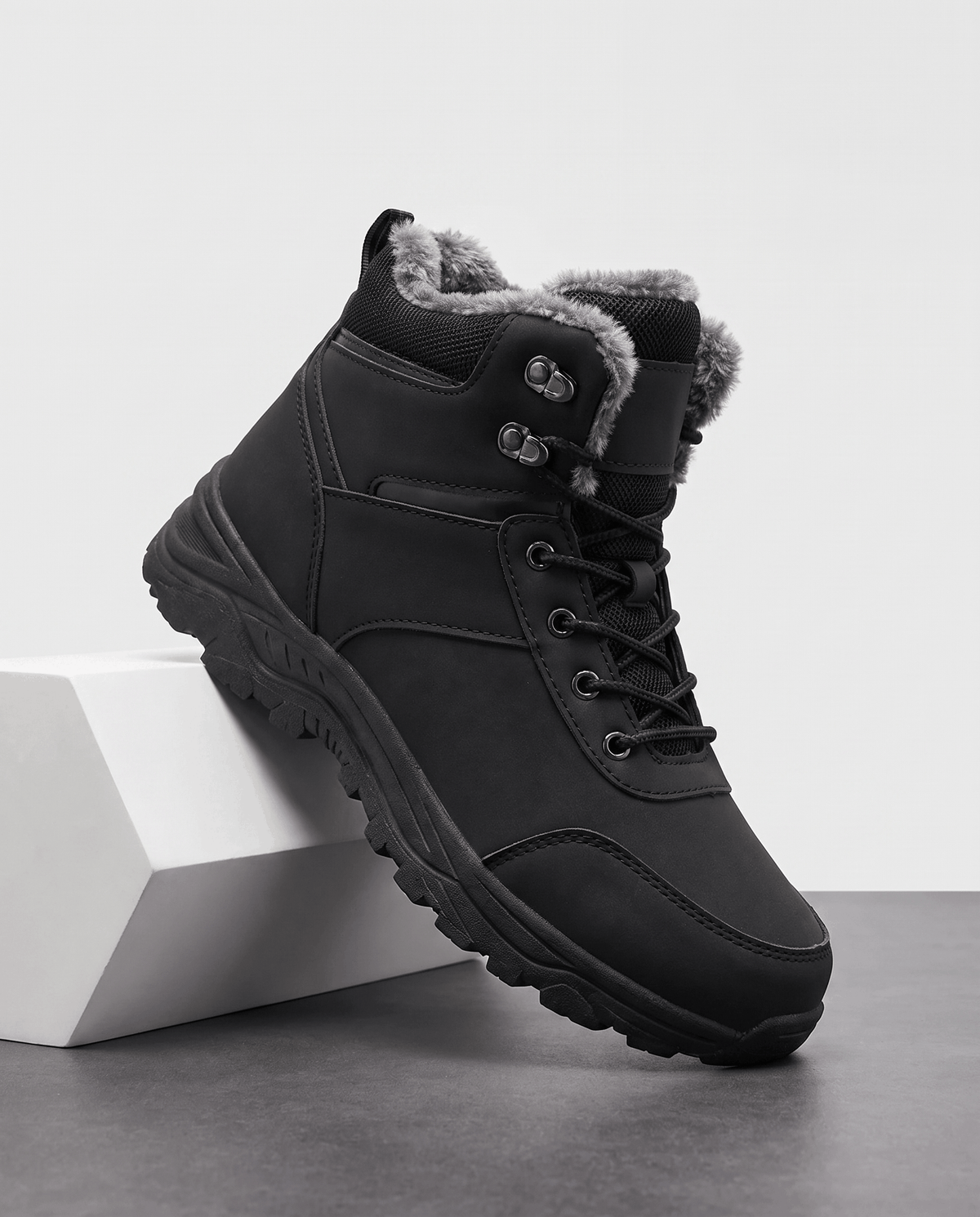 Black insulated winter boot shown on a white pedestal.
