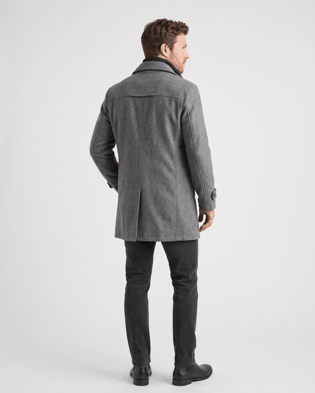 Back view of the gray overcoat worn with dark trousers and black shoes
