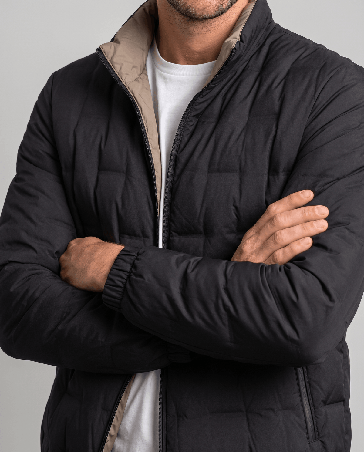 Close-up of the black Sutton quilted down jacket with beige inner collar, elasticated cuffs and zip side pocket