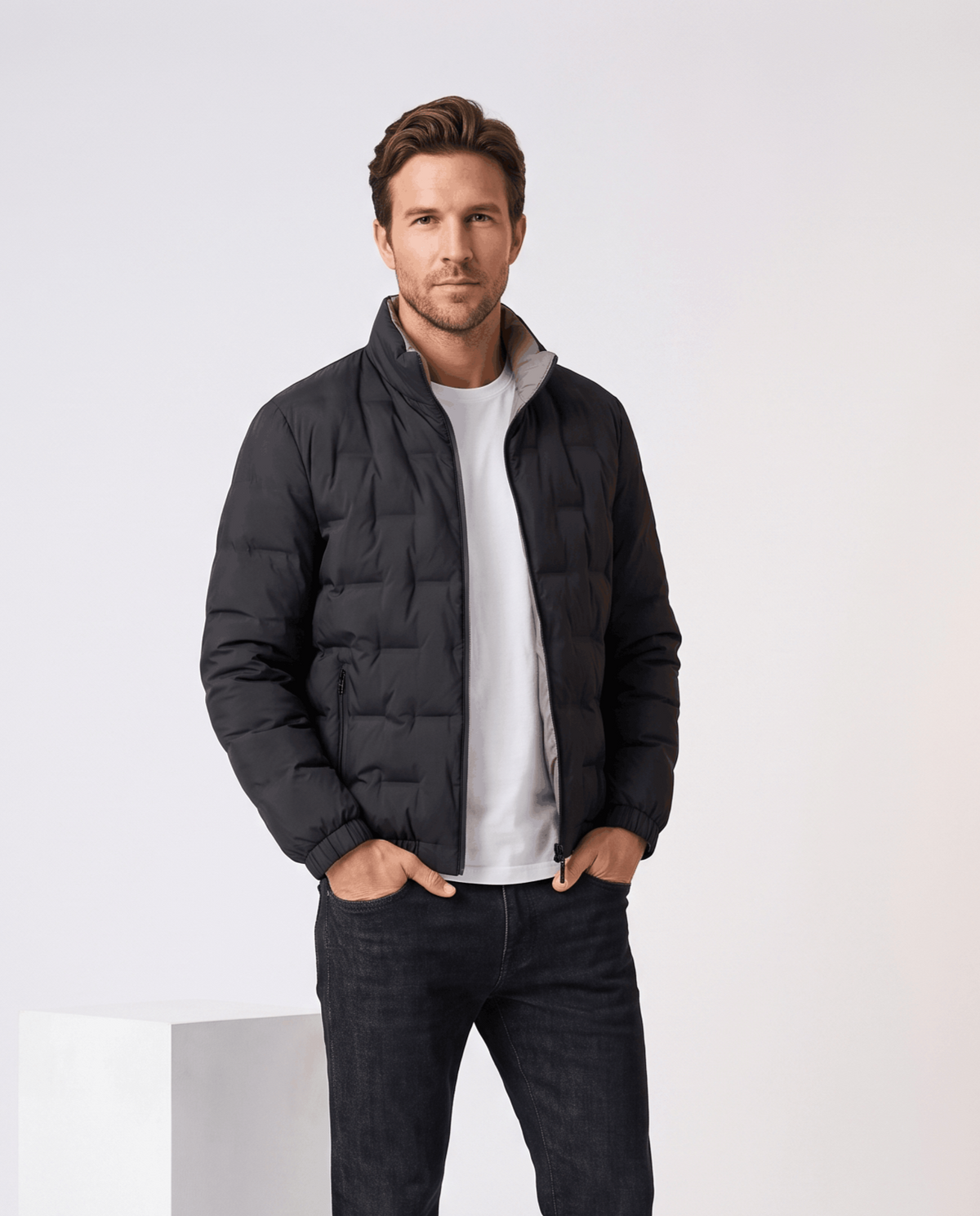 Man wearing the black Sutton quilted down jacket open over a white tee with dark jeans