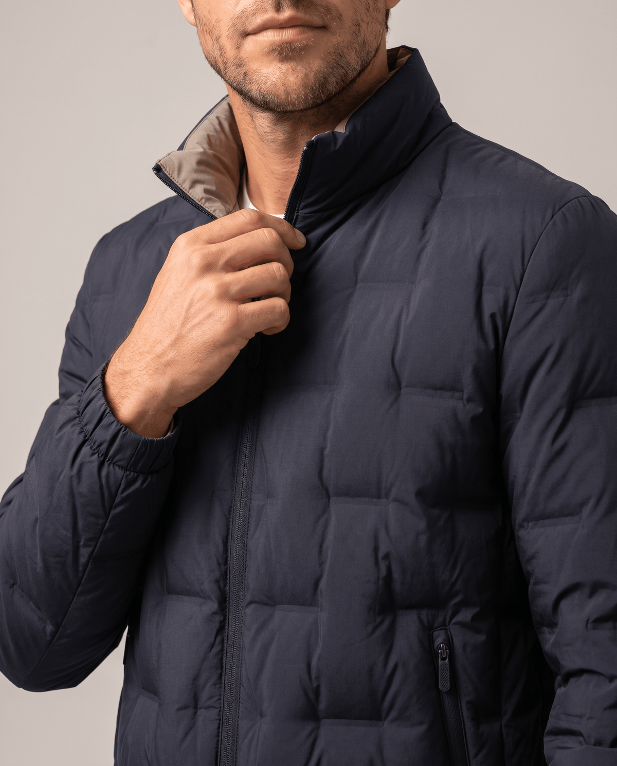 Detail of the blue Sutton quilted down jacket stand collar, front zip and beige inner collar