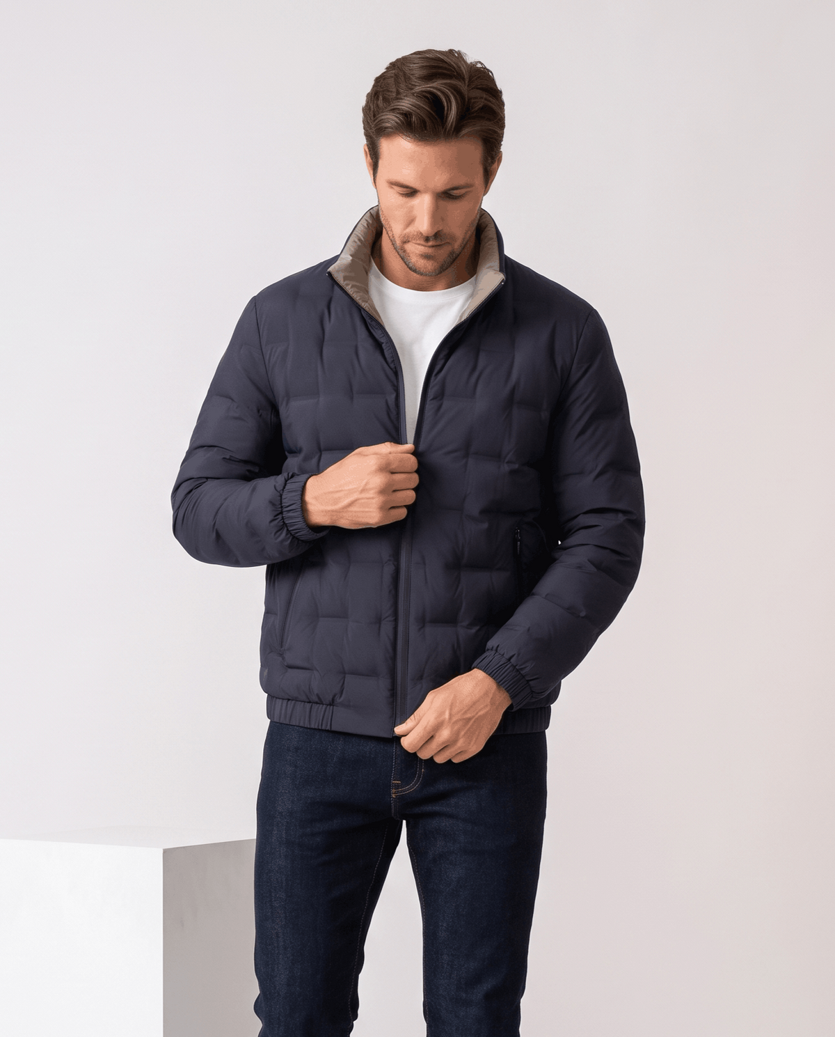 Man wearing the blue Sutton quilted down jacket over a white tee with dark trousers