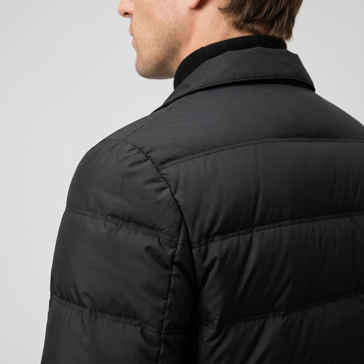 Close shoulder and collar detail in black, showing the lapel seam from behind