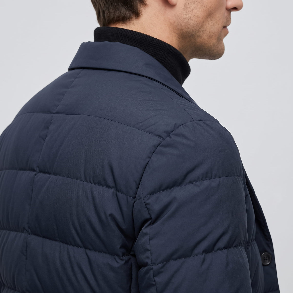 Shoulder and upper-back detail in navy, showing the quilted channel seams
