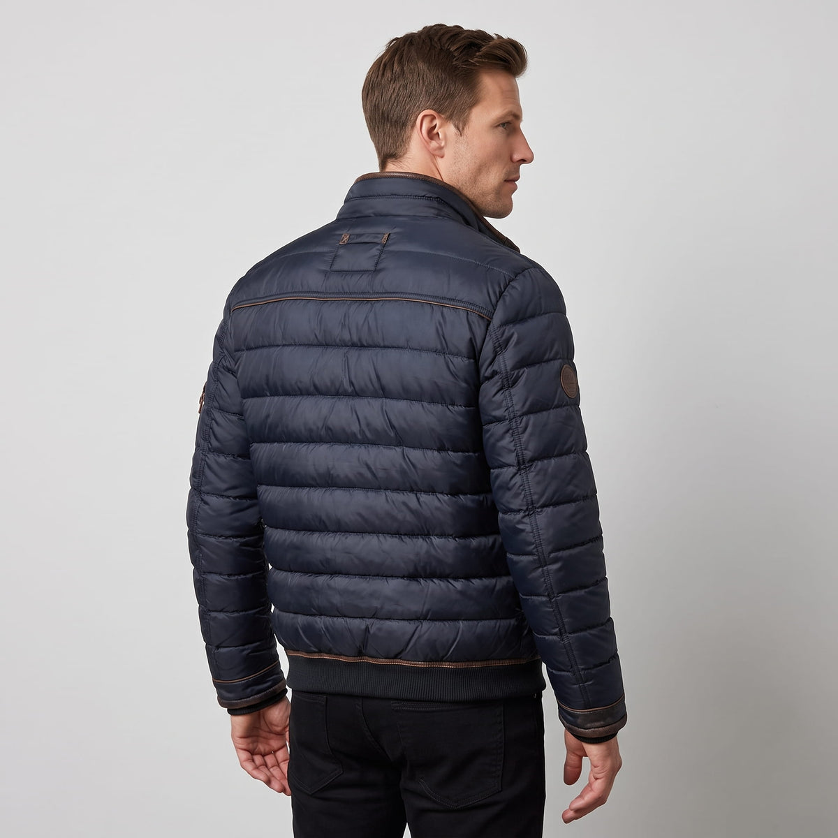 Back view showing quilted panels, tan hem binding and the upright collar