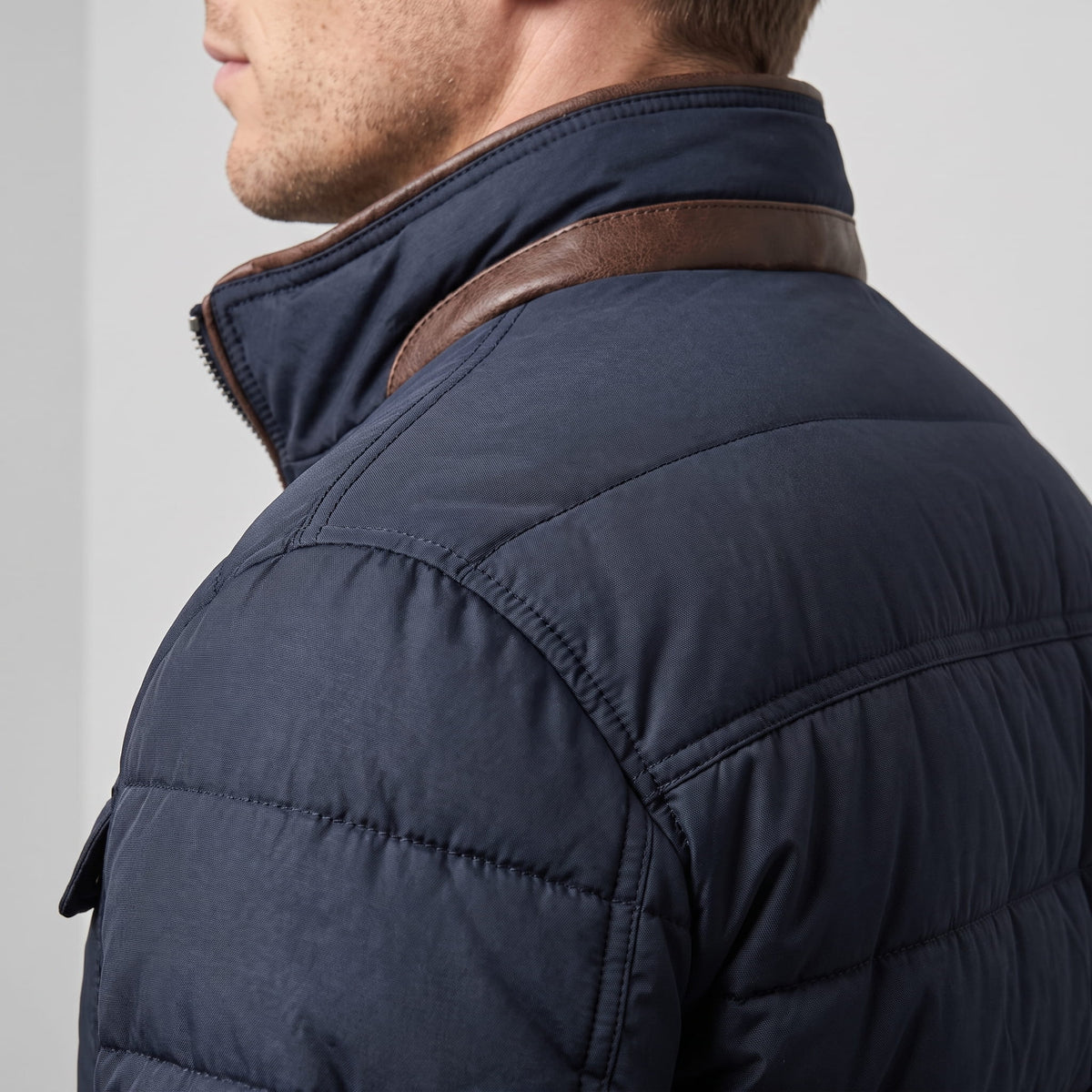 Collar detail from behind, showing the tan facing folded over the navy shell