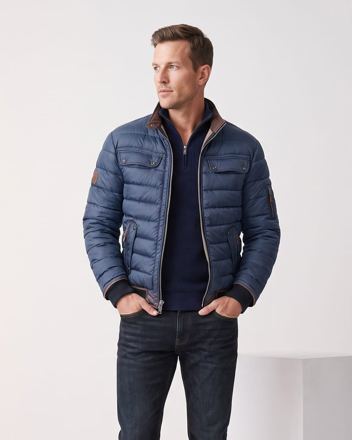 Man wearing navy quilted puffer bomber jacket with tan leather-look collar trim