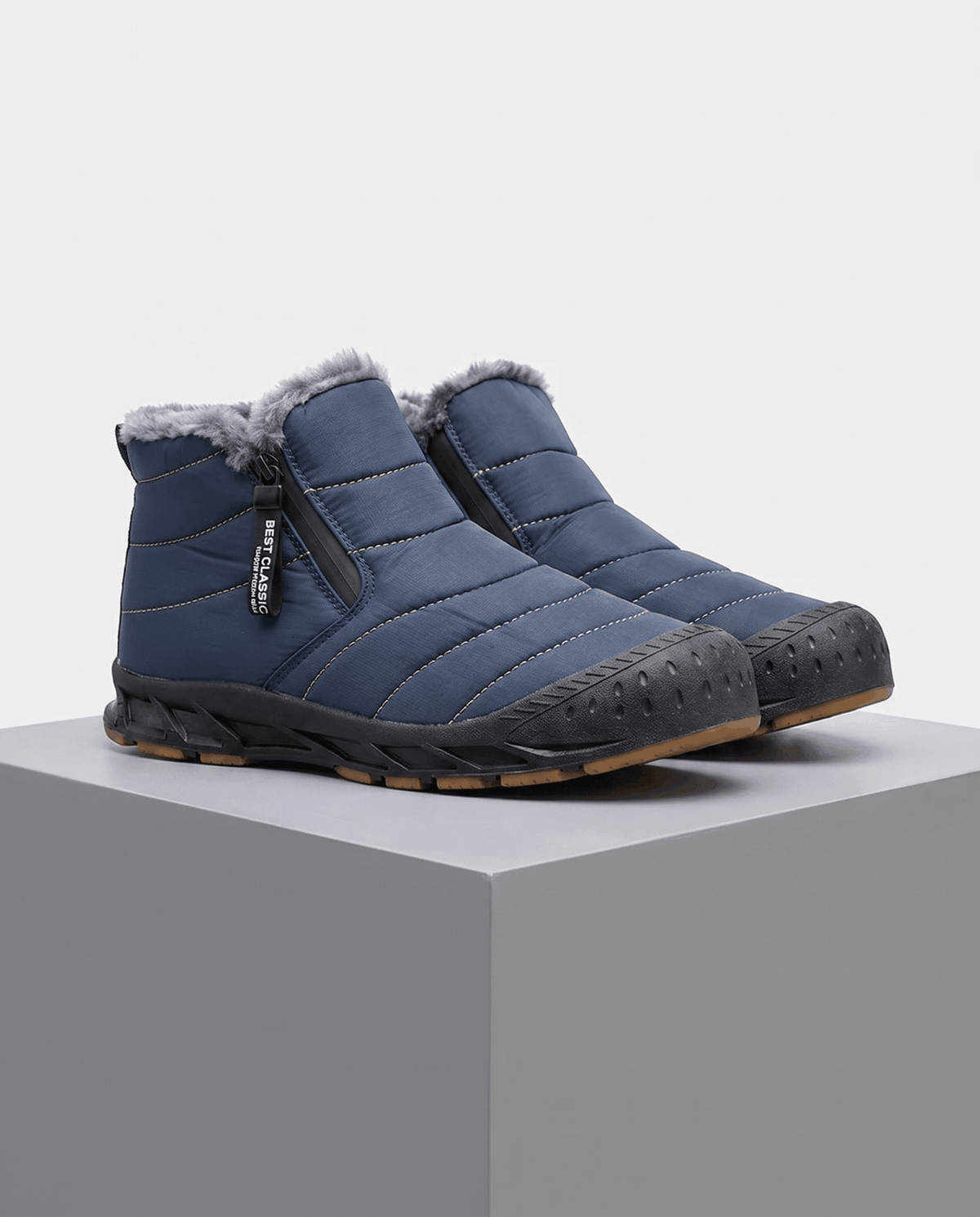 Blue insulated ankle boots displayed on a gray pedestal.