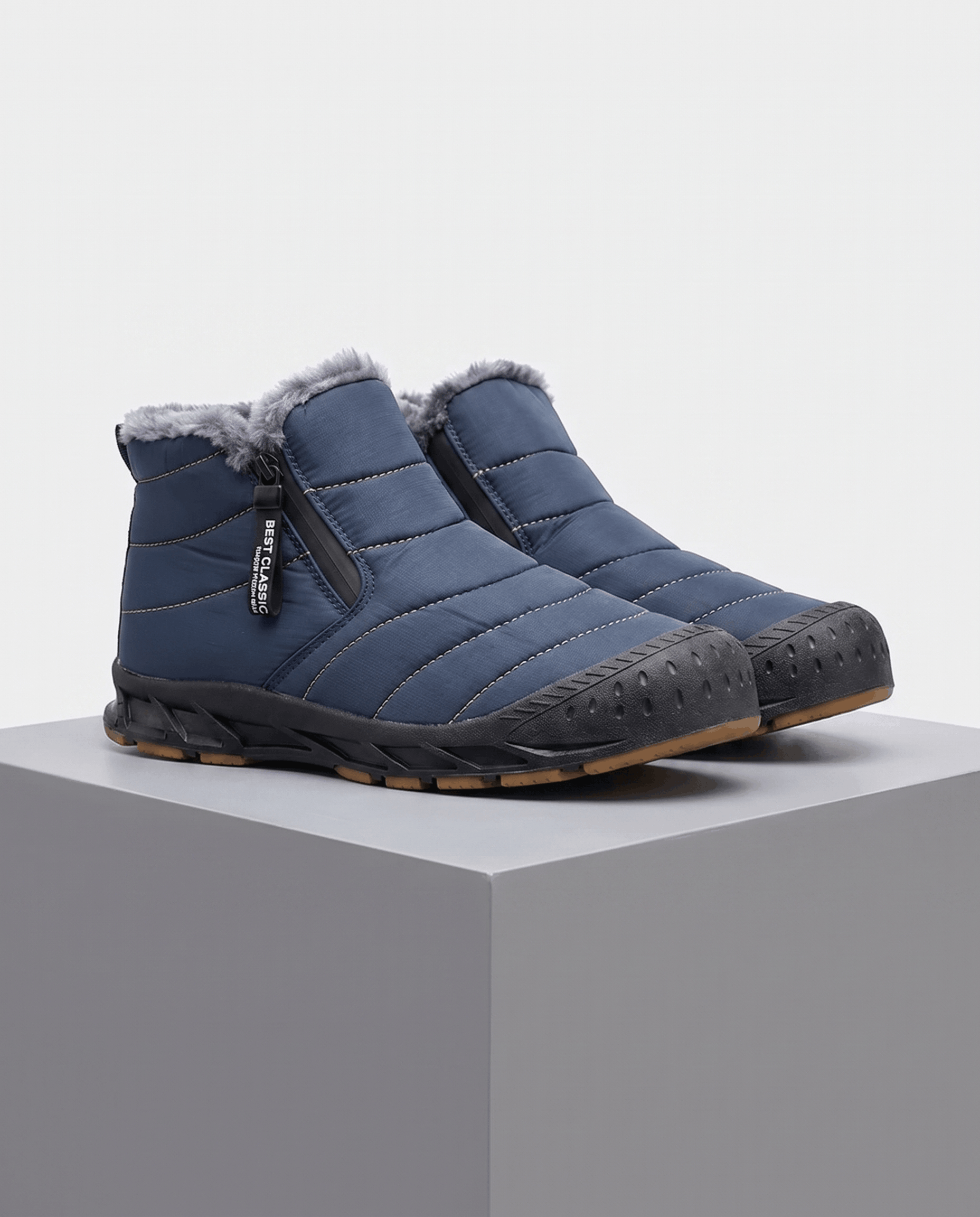 Blue insulated ankle boots displayed on a gray pedestal.