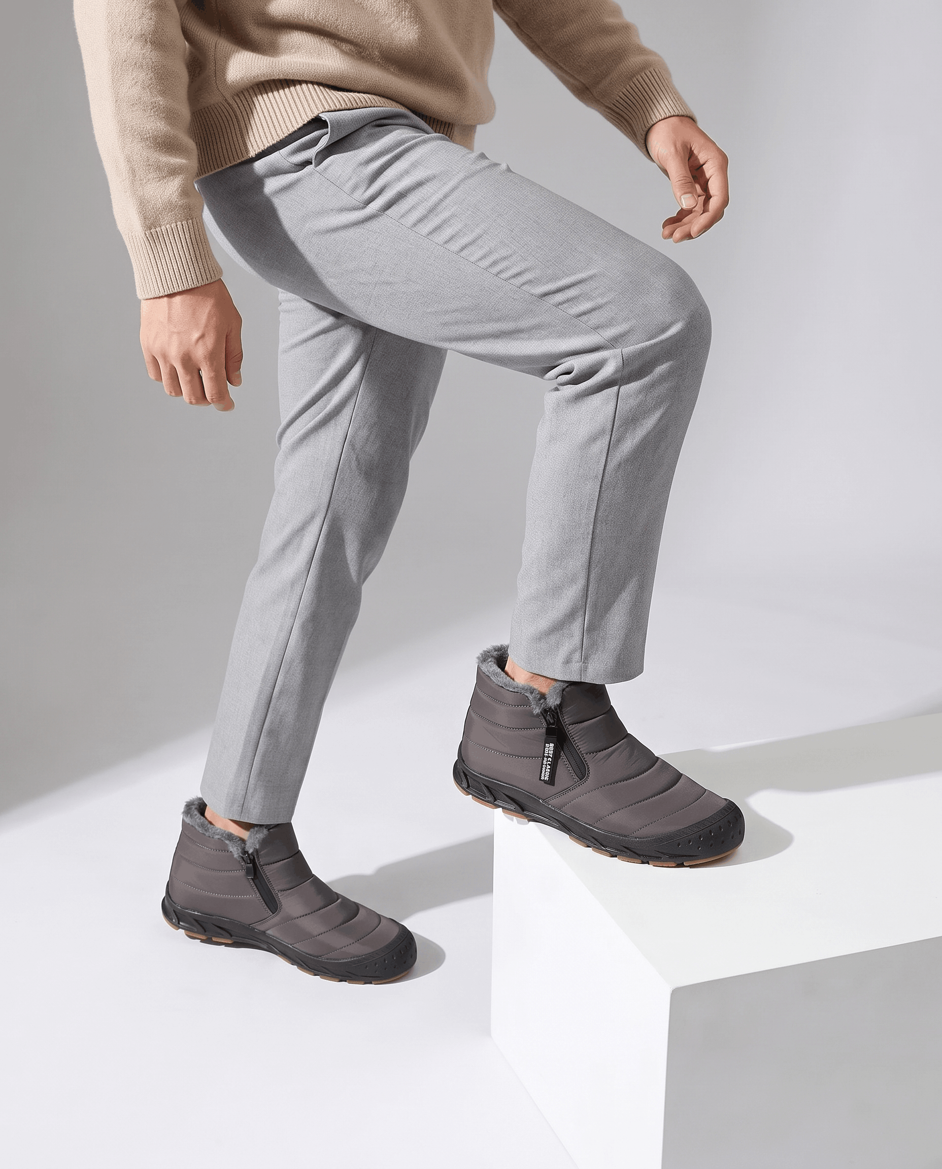 Person wearing gray insulated boots with light gray pants.