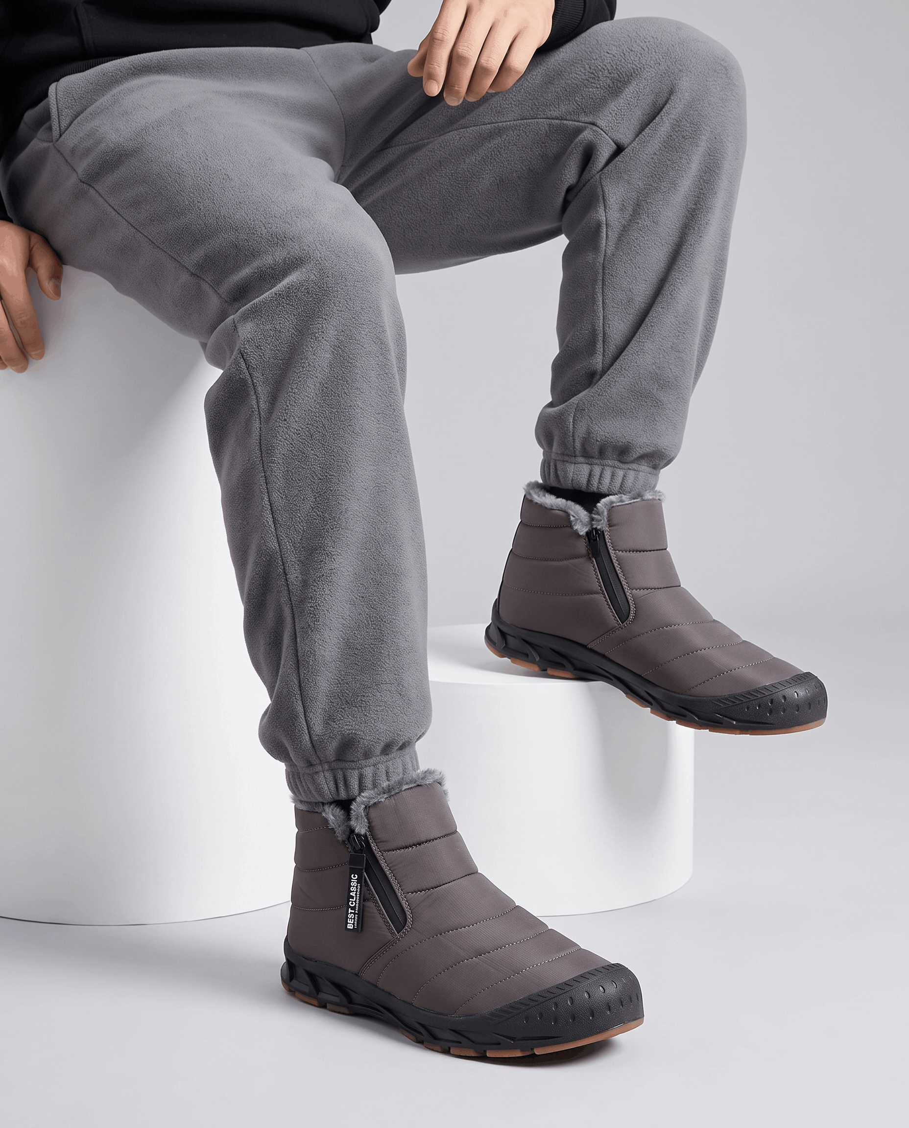 Close-up of gray insulated boots worn with gray pants.