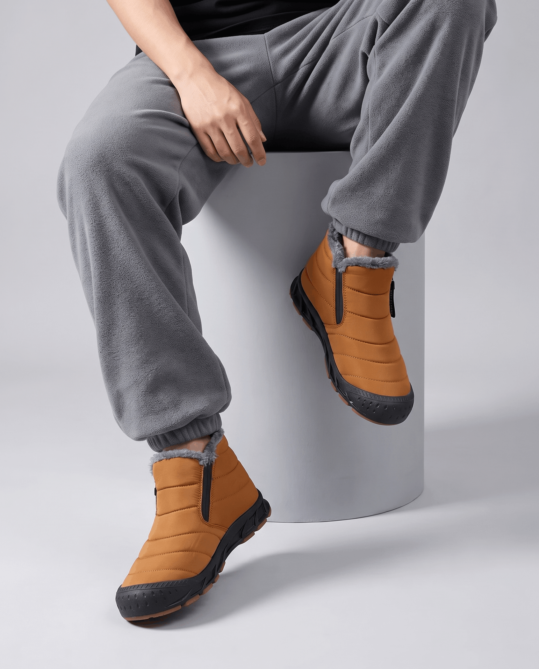Person wearing orange insulated boots with gray pants.