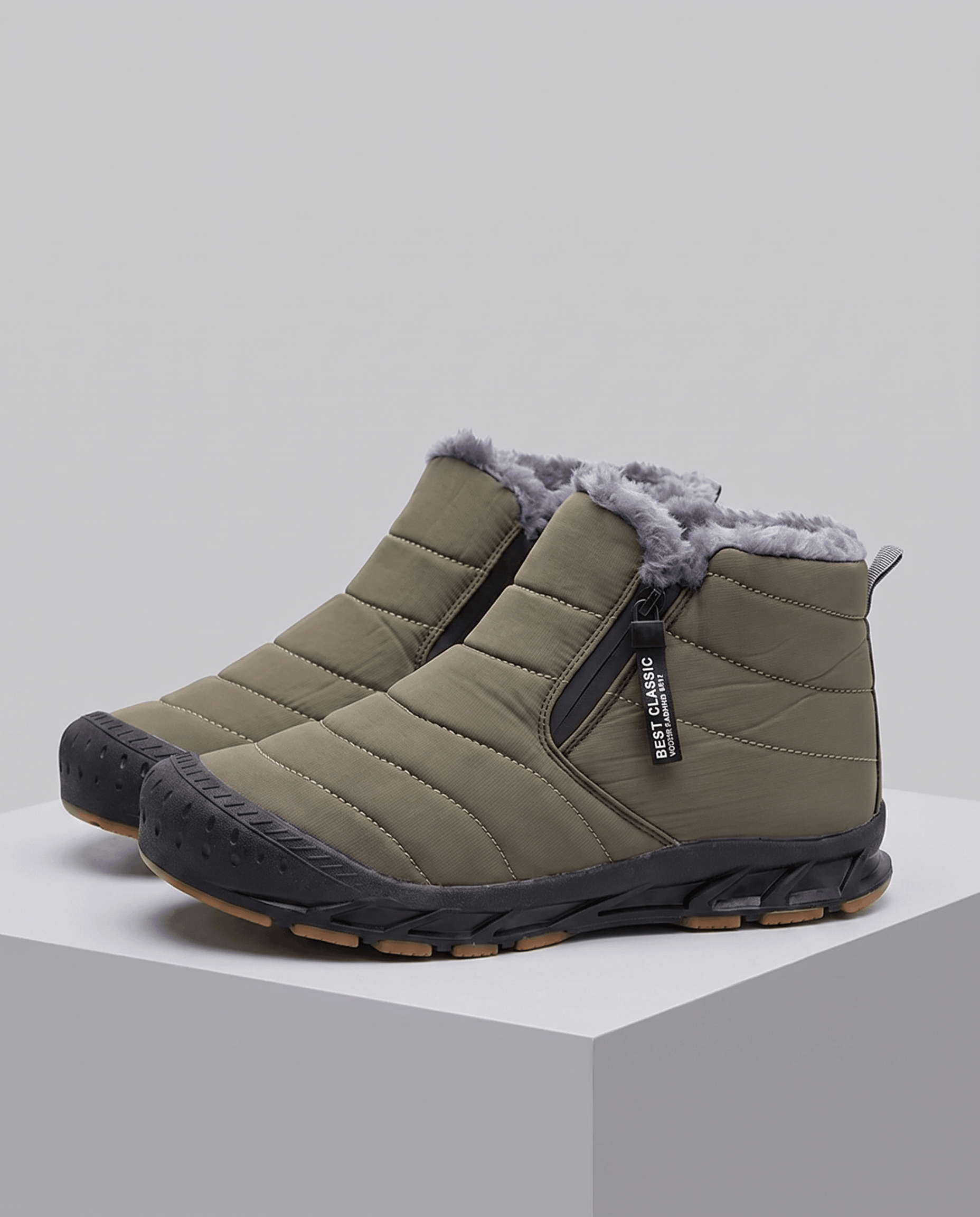 Pair of green insulated boots displayed on a gray pedestal.