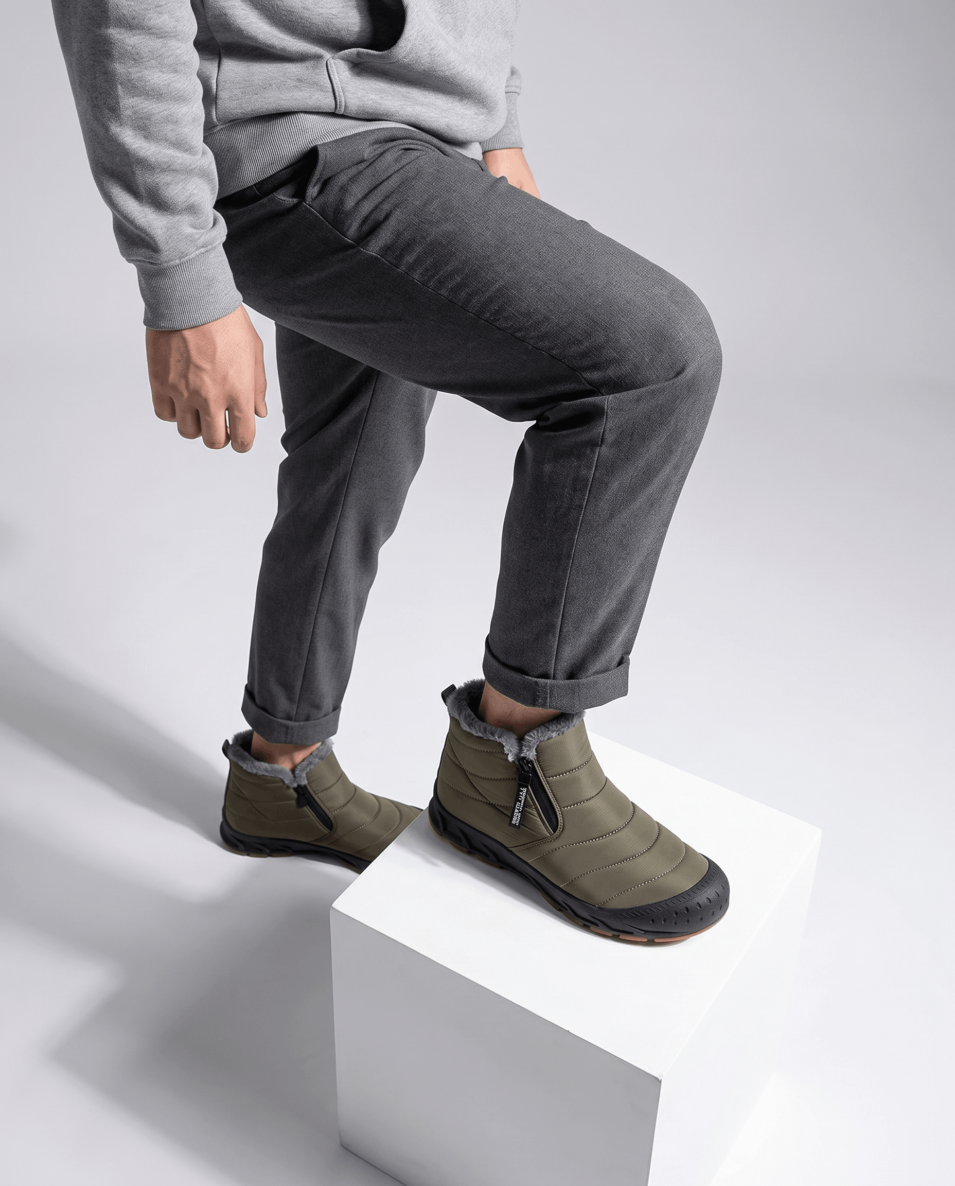 Person wearing green insulated boots while standing on white steps.