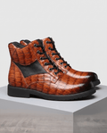 Brown embossed reptile-grain leather ankle boots with black panel insets, polished metal eyelets, and a chunky lug outsole.