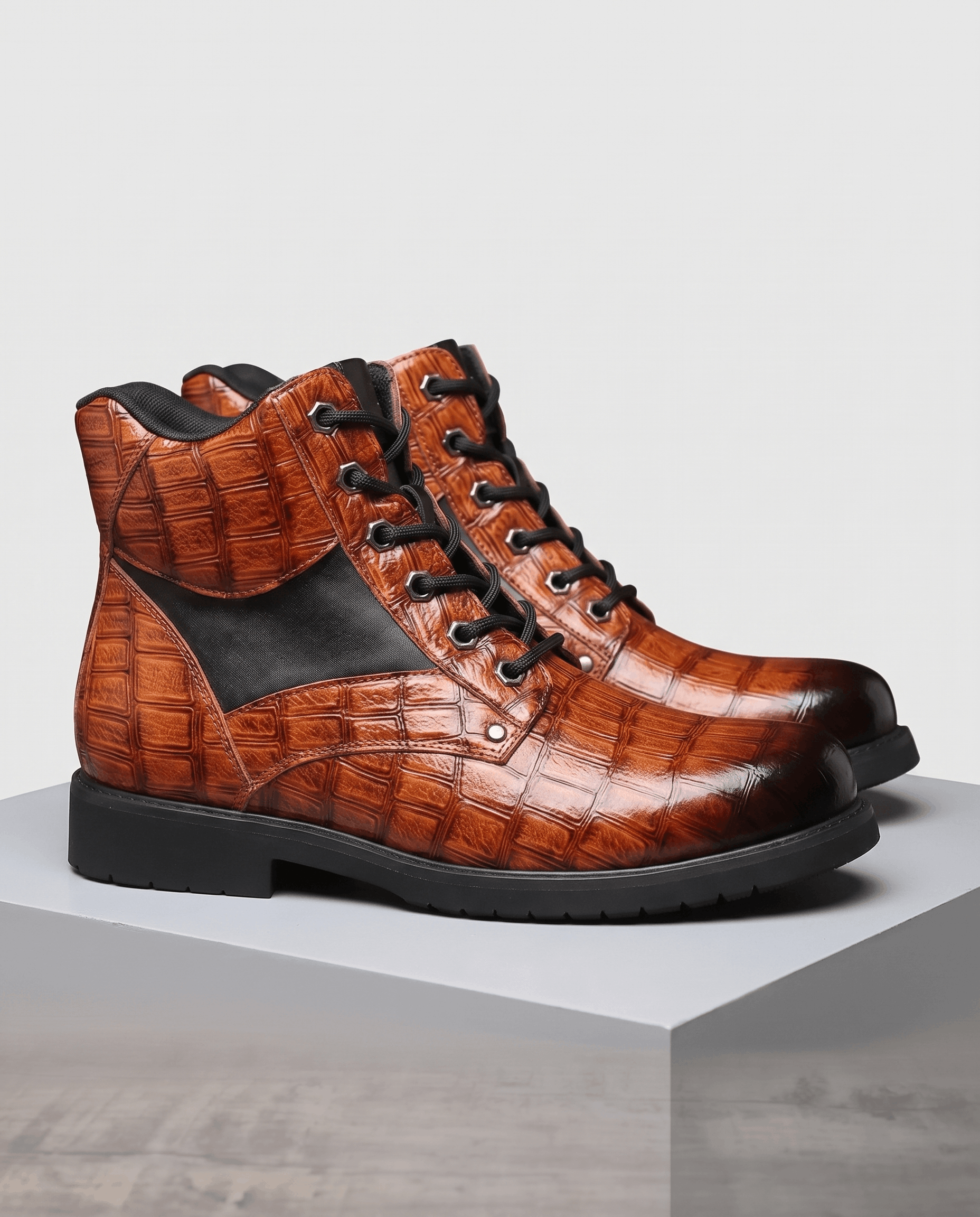 Brown embossed reptile-grain leather ankle boots with black panel insets, polished metal eyelets, and a chunky lug outsole.