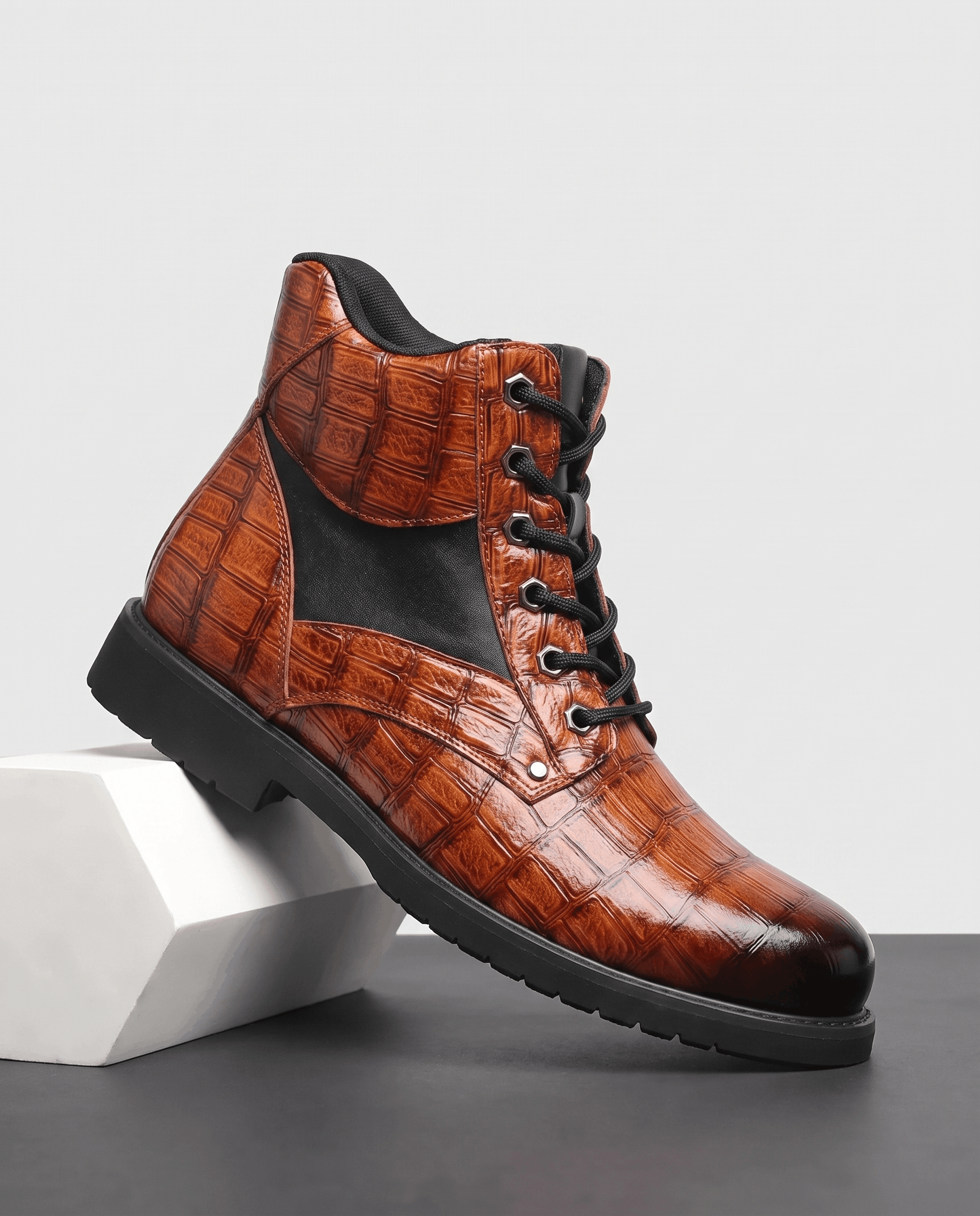 Brown embossed reptile-grain leather ankle boots with black panel insets, polished metal eyelets, and a chunky lug outsole.