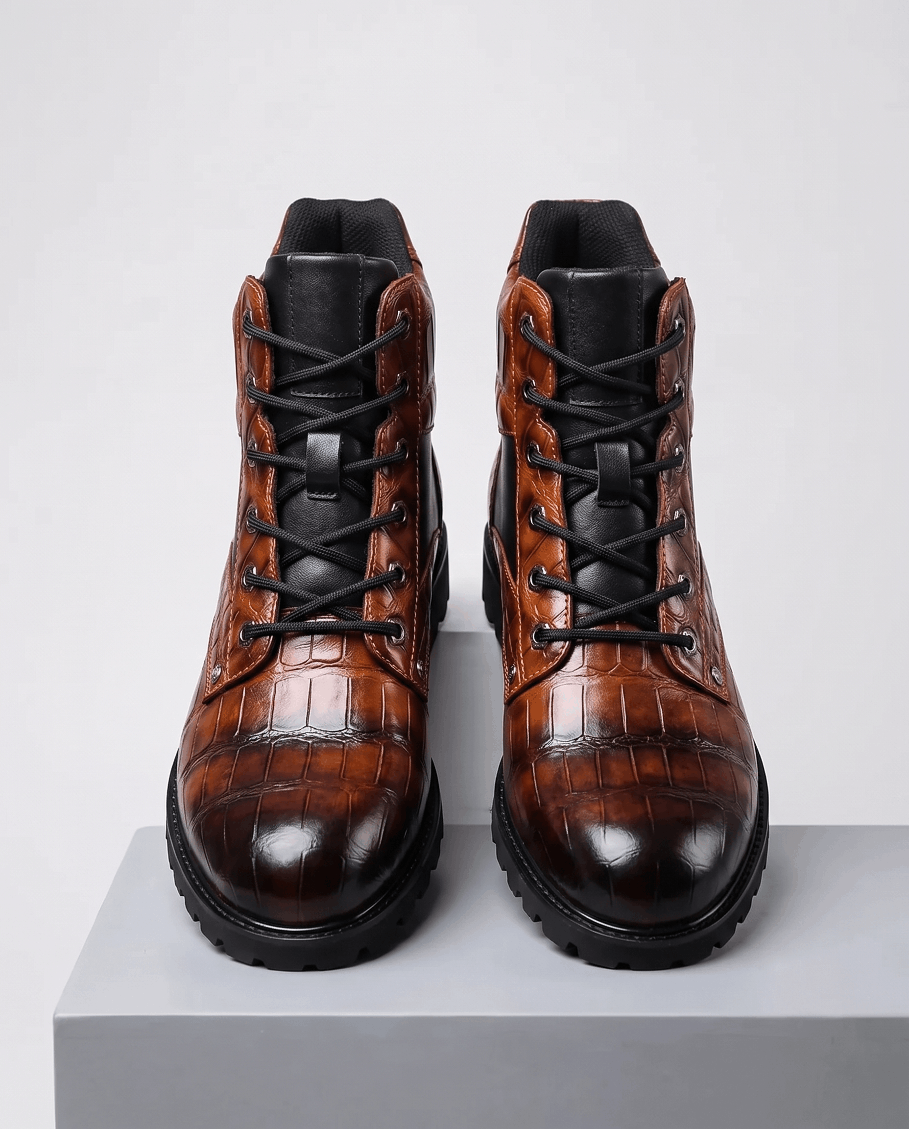 Dark brown embossed reptile grain leather lace-up ankle boots with polished metal eyelets and a chunky black lug outsole.