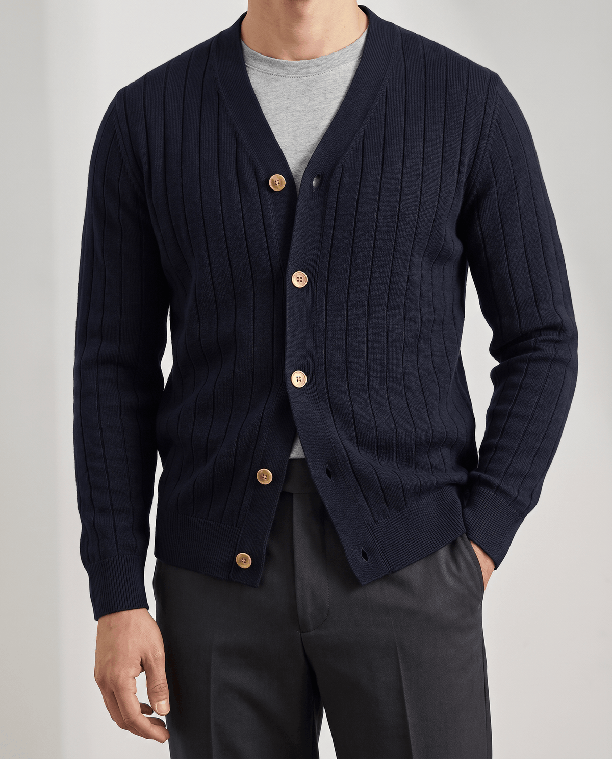 Navy V-neck cardigan with tan buttons worn over a gray tee