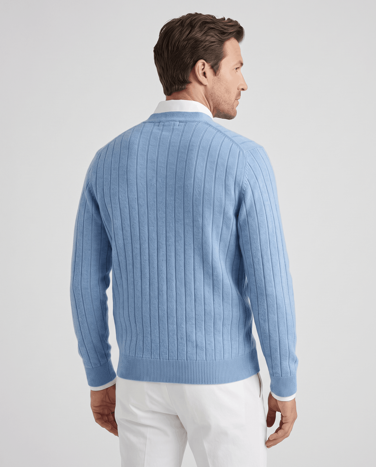 Back view of the sky blue ribbed cardigan with white trousers
