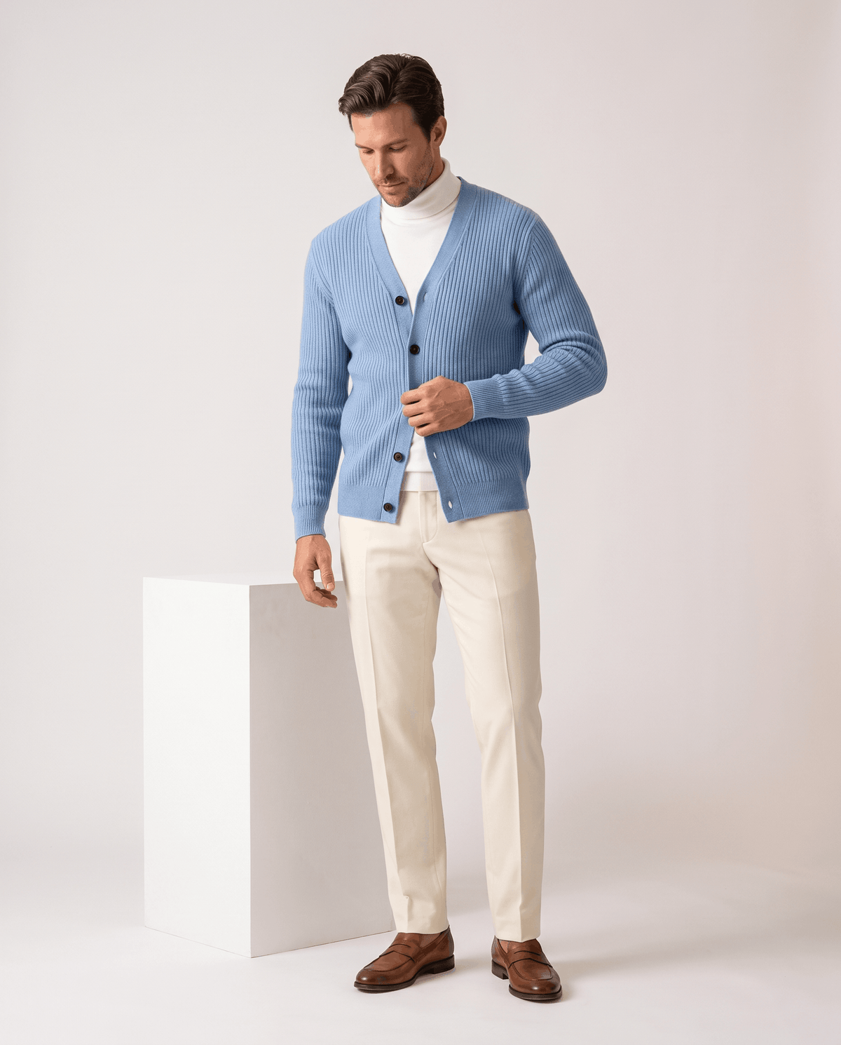 Full-length view of the sky blue cardigan with cream trousers and brown shoes