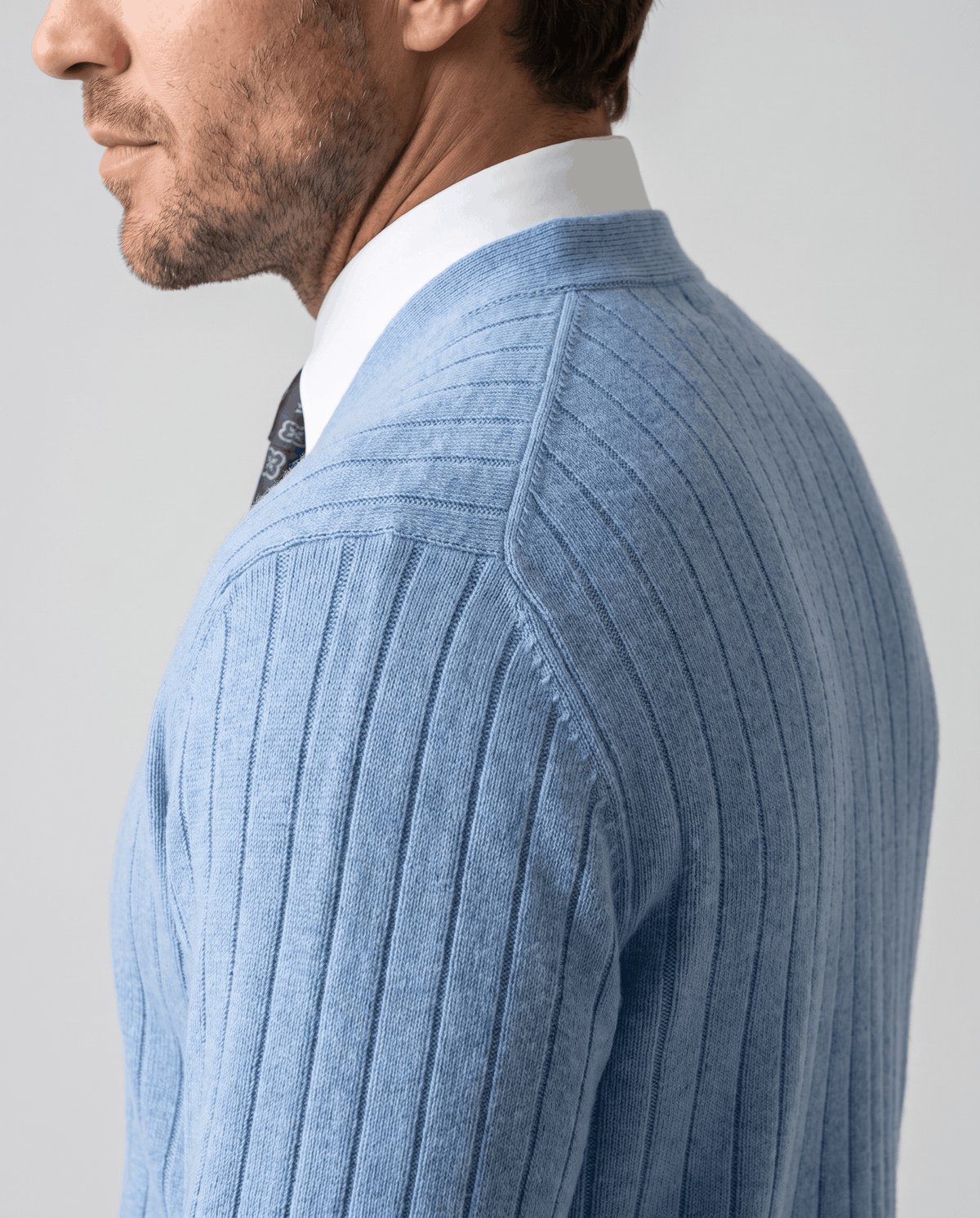 Side profile of the sky blue cardigan showing the vertical rib knit at the shoulder