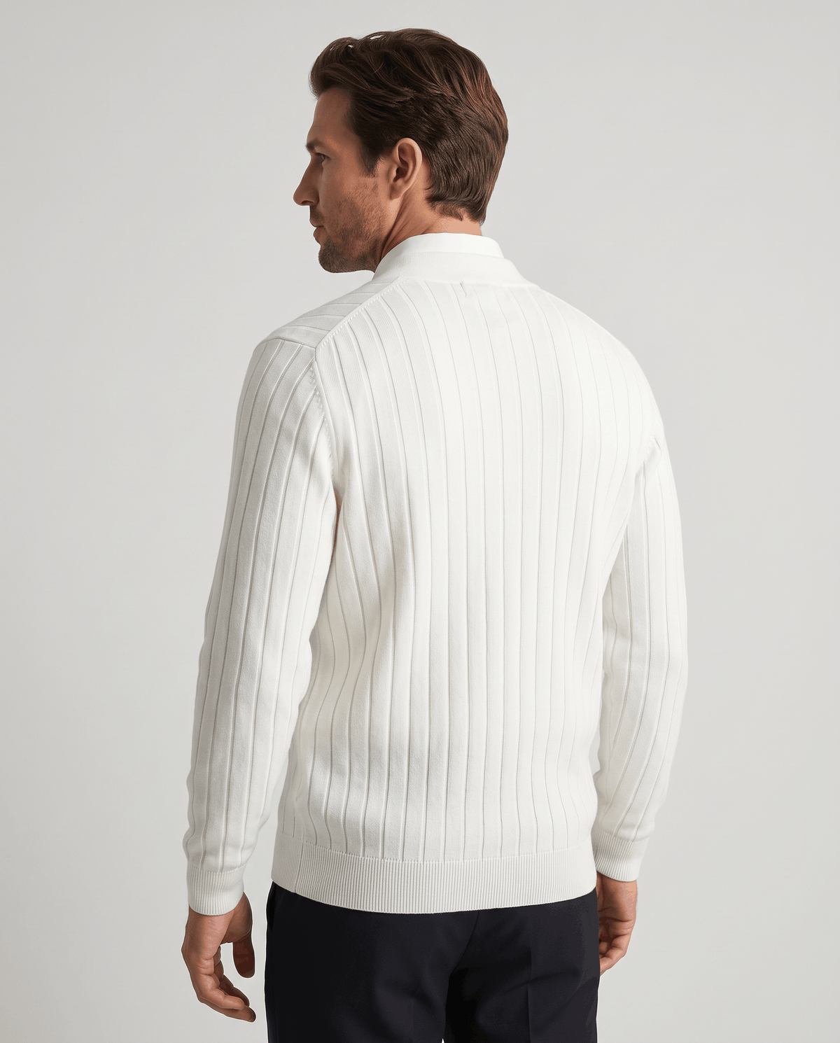 Back view of the white ribbed V-neck cardigan with dark trousers