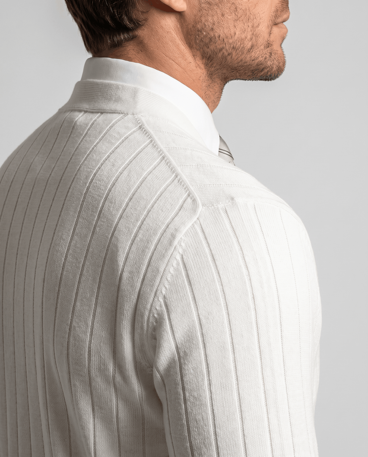 Side profile of the white knit showing the ribbed texture at the shoulder