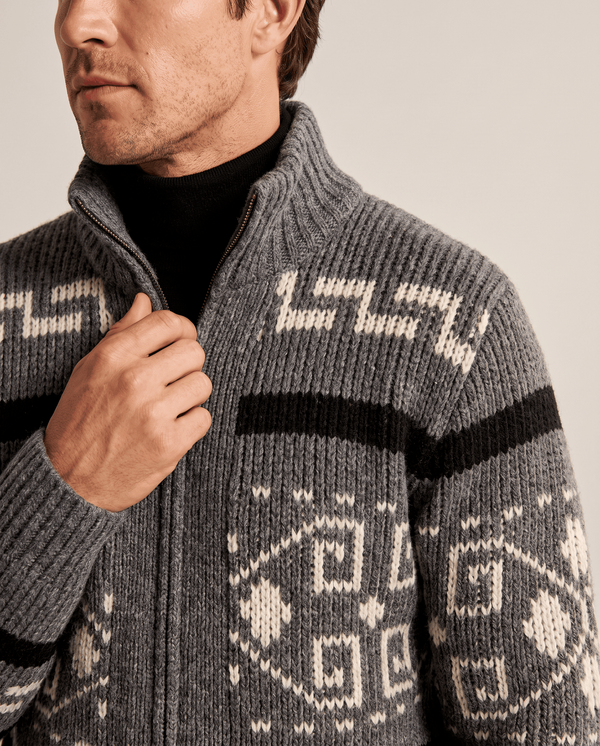 Gray shawl collar cardigan over a black turtleneck, close view of zip front