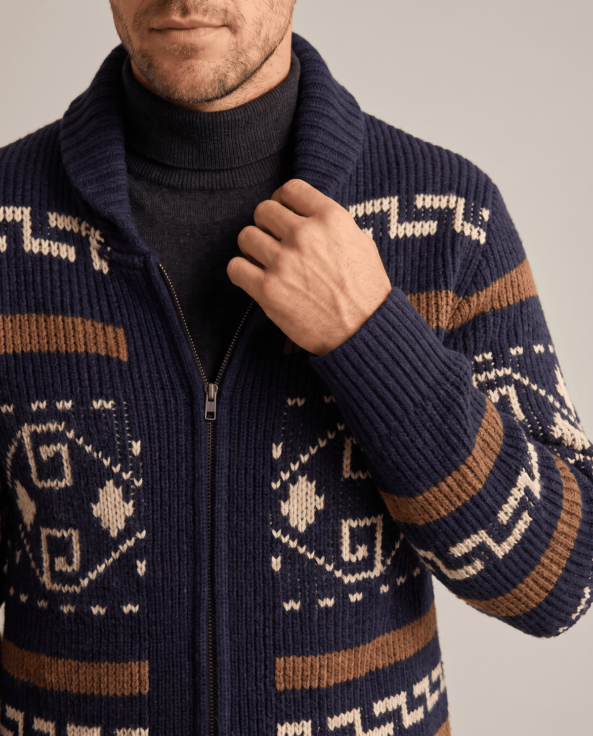 Navy blue shawl collar cardigan over a black turtleneck, close view of zip and pattern