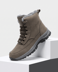 Khaki sherpa-lined lace-up winter boot with a padded tongue and rugged lug sole displayed on white blocks.