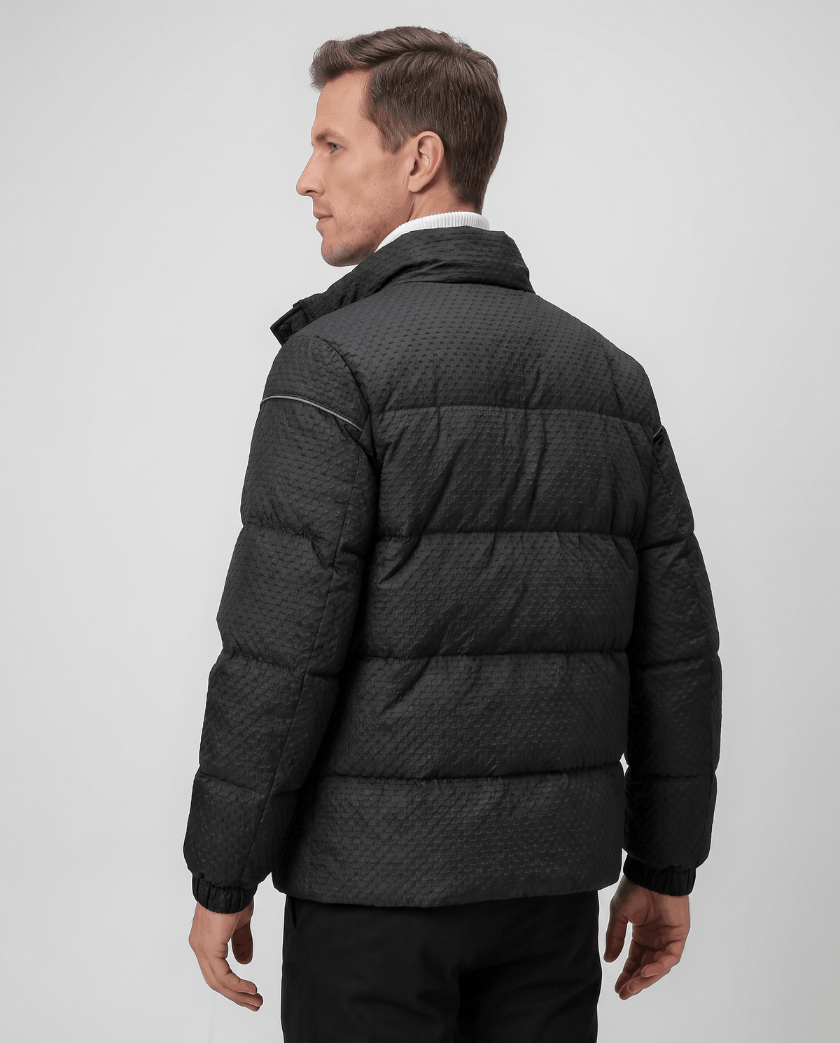 Back view of a black puffer showing sleeve piping and padded channels