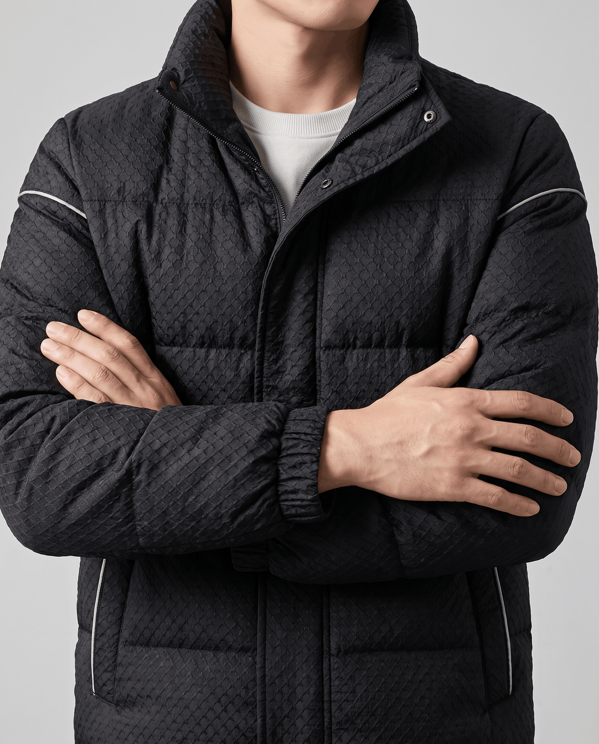 Chest detail of a black puffer showing the snap placket and sleeve piping