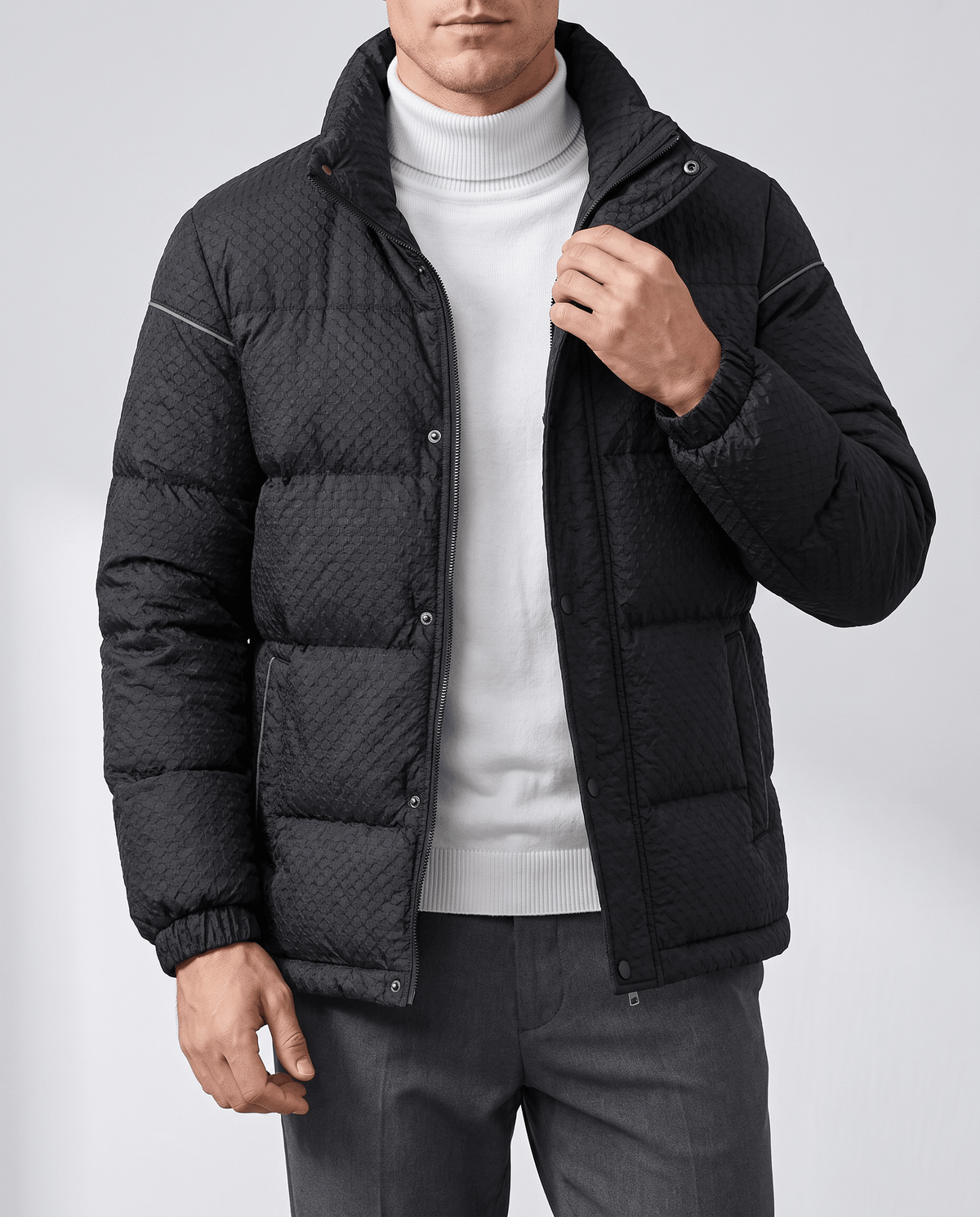 Model adjusting the stand collar on a black puffer with snap placket showing