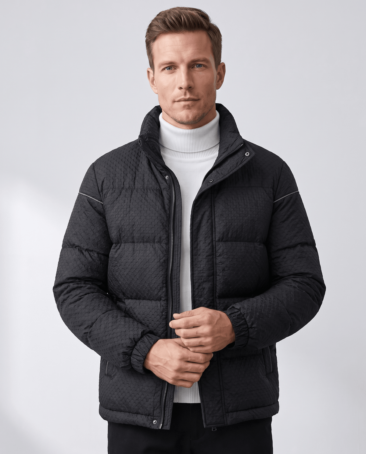 Black puffer jacket front view worn open over a white knit turtleneck