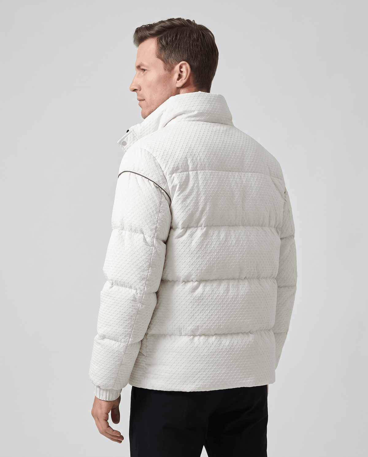 Back view of a white puffer showing padded channels and sleeve piping