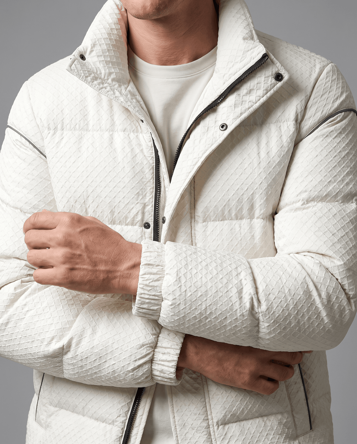 Chest detail of a white puffer showing snap placket and ribbed cuff trim