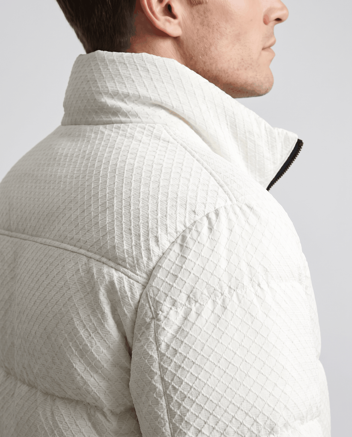 Close-up of the embossed texture across a white puffer collar and shoulder