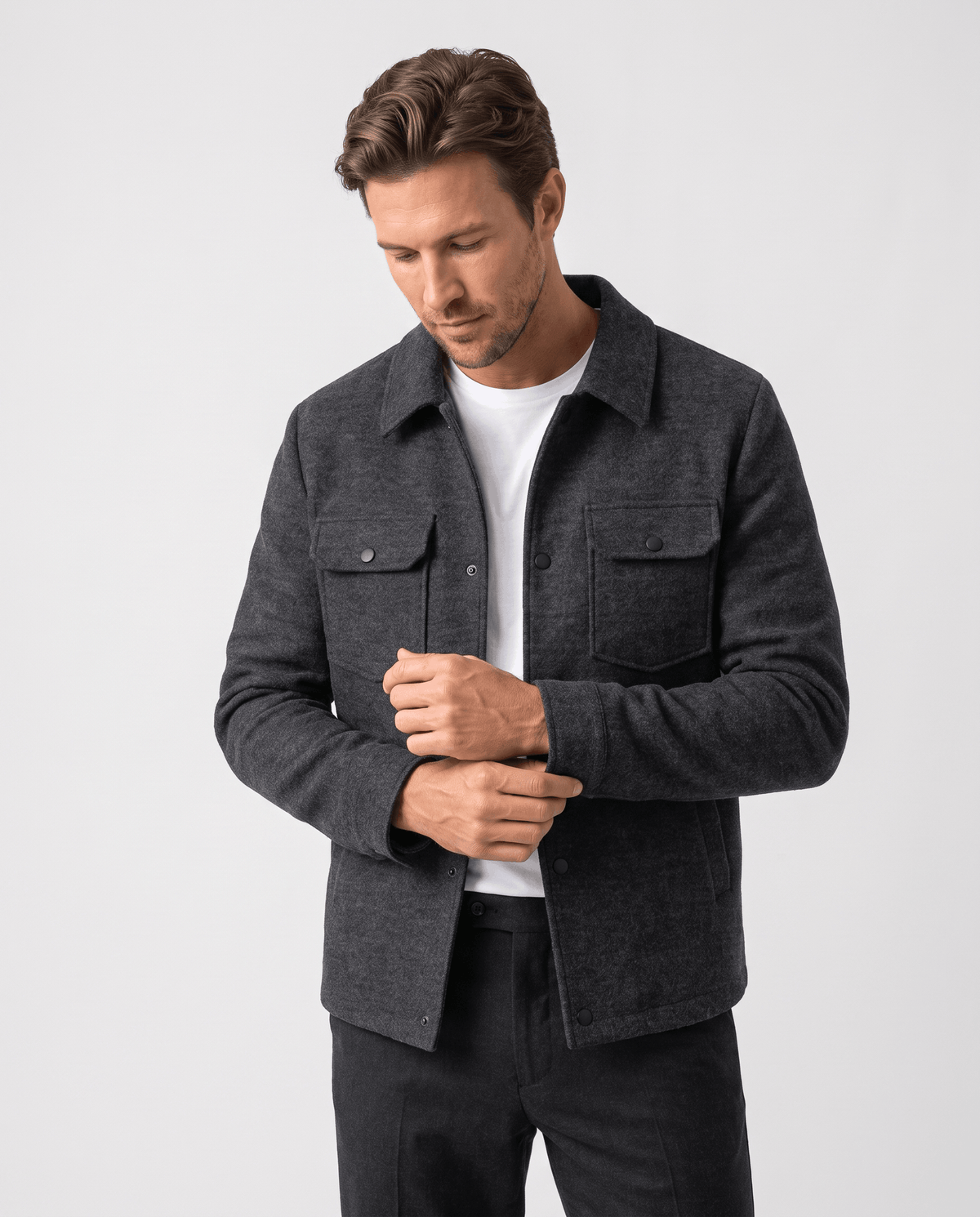 Model fastening the front of the dark gray wool-blend jacket at chest height
