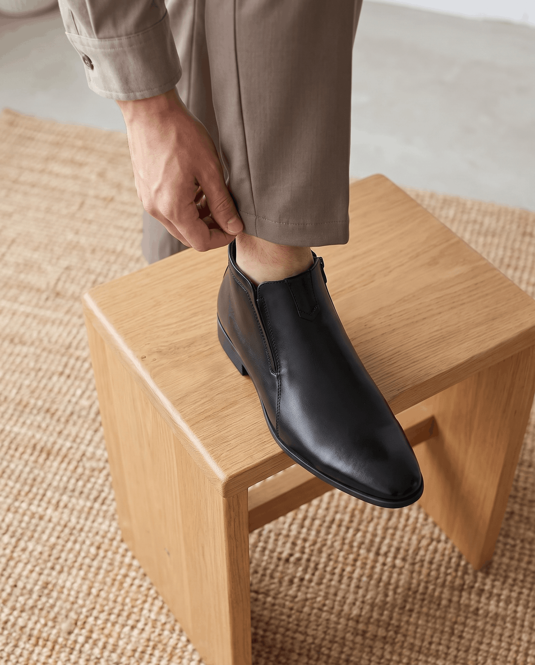 Black polished grain leather ankle boots featuring a pointed toe, notched topline, and side zip closure on a block heel.
